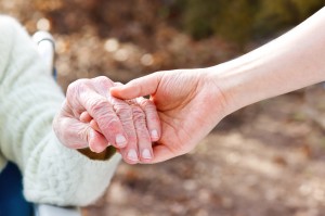 Senior Lady Holding Hands with Young Caretaker
